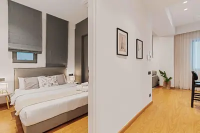 a bedroom with a bed and a dining room at Ray the Second - 1BR, Exarcheia in Athens
