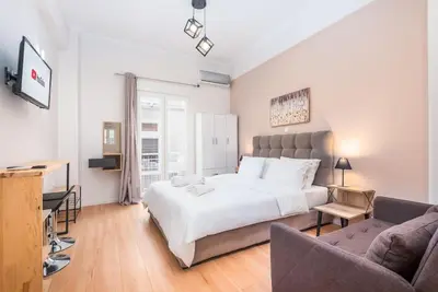 a bedroom with a large white bed and a couch at Beautiful central apartment next to the Metro in Athens