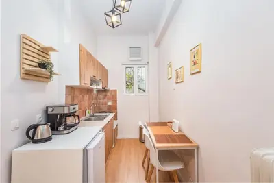 a kitchen with a white refrigerator and a wooden table at Beautiful central apartment next to the Metro in Athens