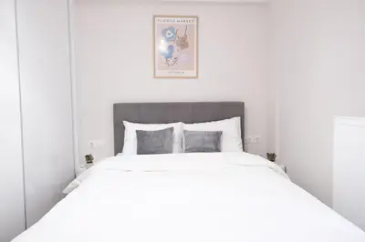 a white bedroom with a large white bed with two pillows at Cozy Hideaway Nearby Acropolis & Metro in Athens
