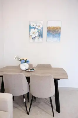 a dining room table with chairs and paintings on the wall at Cozy Hideaway Nearby Acropolis & Metro in Athens