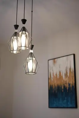 two lights hanging in a room with a painting at Cozy Hideaway Nearby Acropolis & Metro in Athens