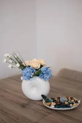 a white vase with blue flowers and a plate of food at Cozy Hideaway Nearby Acropolis & Metro in Athens