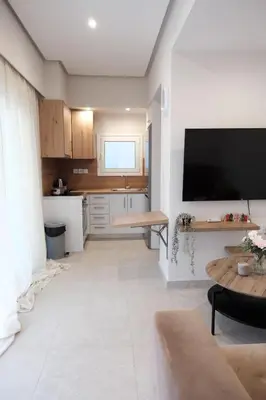 a living room with a tv and a kitchen at Cozy Penthouse Nearby Acropolis & Metro in Athens