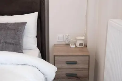 a bedroom with a bed and a nightstand with a lamp at Cozy Penthouse Nearby Acropolis & Metro in Athens