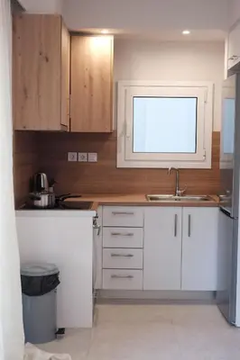 a kitchen with white cabinets and a sink at Cozy Penthouse Nearby Acropolis & Metro in Athens