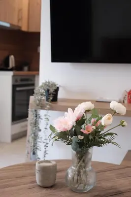 a vase of pink flowers sitting on a table at Cozy Penthouse Nearby Acropolis & Metro in Athens