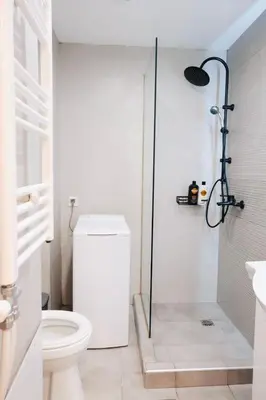 a white bathroom with a shower and a toilet at Cozy Penthouse Nearby Acropolis & Metro in Athens