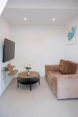 a living room with a brown couch and a table at Cozy Penthouse Nearby Acropolis & Metro in Athens
