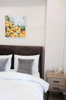 a bedroom with a bed and a painting on the wall at Cozy Penthouse Nearby Acropolis & Metro in Athens