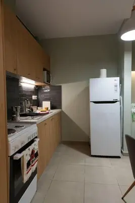 a kitchen with a white refrigerator and a stove at Urban Maisons in Athens