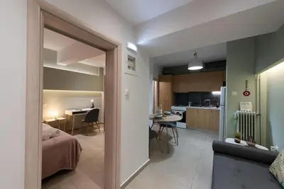 a room with a bed and a kitchen with a table at Urban Maisons in Athens