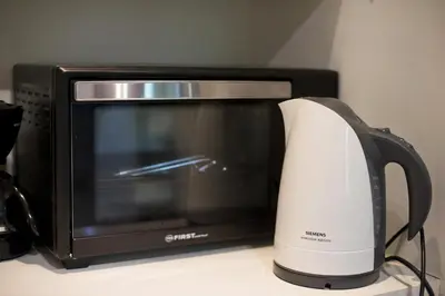 a microwave and a toaster oven on a counter at Cozy and modern studio Vouliagmeni Steps to Beach in Athens