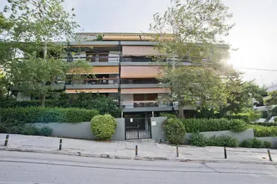 an apartment building with a gate in front of a street at Cozy and modern studio Vouliagmeni Steps to Beach in Athens