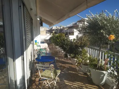 a balcony with a blue table and chairs and plants at Central 2-Bedroom penthouse in Athens