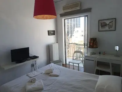 a bedroom with a bed and a desk and a window at Central 2-Bedroom penthouse in Athens