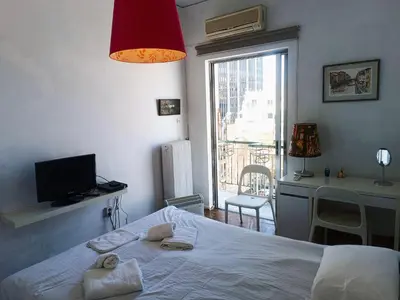 a bedroom with a bed and a desk and a window at Central 2-Bedroom penthouse in Athens