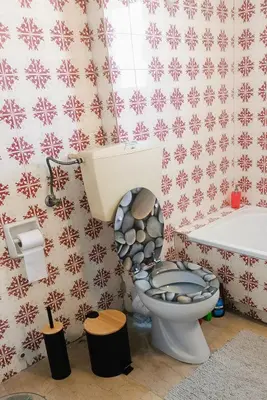 a bathroom with a toilet with a snowman patterned wall at Central 2-Bedroom penthouse in Athens