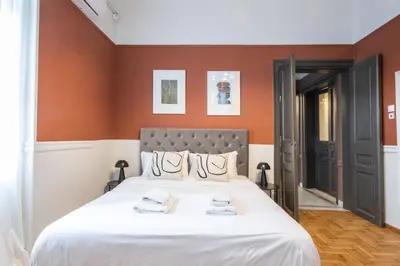 a bedroom with a large bed with orange walls at Vintage Acropolis Retreat Charming 3-Bdrm in Koukaki in Athens