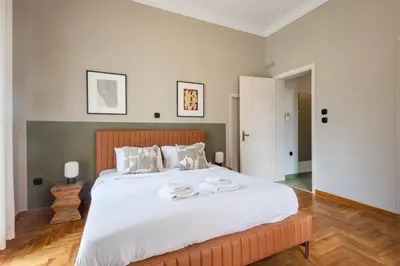 a bedroom with a large bed with white sheets at Acropolis View Rooftop Garden & Jacuzzi in Athens