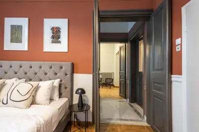 a bedroom with orange walls and a bed and a mirror at Acropolis View Rooftop Garden & Jacuzzi in Athens