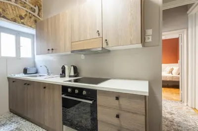 a kitchen with wooden cabinets and a sink at Acropolis View Rooftop Garden & Jacuzzi in Athens