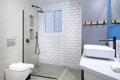 a white bathroom with a toilet and a sink at Modern Corner Apartment in Central Athens, Pagrati in Athens