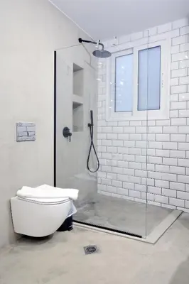 a white bathroom with a shower and a toilet at Modern Corner Apartment in Central Athens, Pagrati in Athens