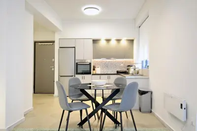 a kitchen and dining room with a table and chairs at Modern Corner Apartment in Central Athens, Pagrati in Athens