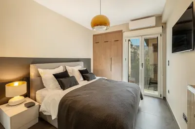 a bedroom with a large bed and a balcony at Alfalfa Pagrati - Stylish Apartment near Caravel & Center in Athens