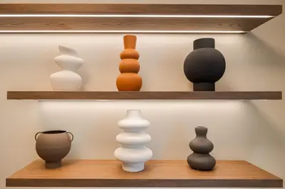 a display of vases and other ceramics on shelves at Alfalfa Pagrati - Stylish Apartment near Caravel & Center in Athens