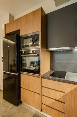 a kitchen with wooden cabinets and an oven at Alfalfa Pagrati - Stylish Apartment near Caravel & Center in Athens