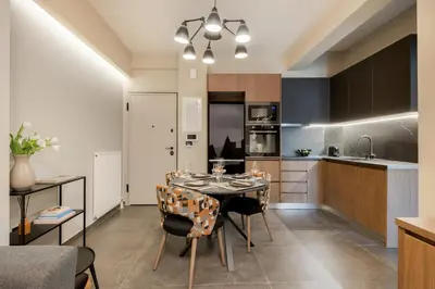 a kitchen and dining room with a table and chairs at Alfalfa Pagrati - Stylish Apartment near Caravel & Center in Athens