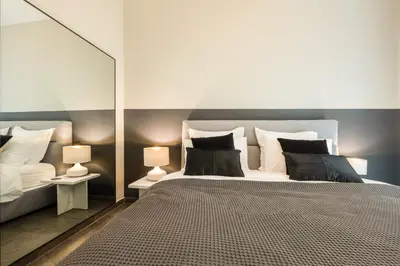 a bedroom with a large bed and two lamps at Alfalfa Pagrati - Stylish Apartment near Caravel & Center in Athens