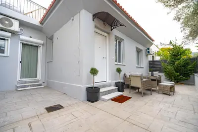 a patio with a table and chairs and a house at Odysseas Palace in Athens in Athens