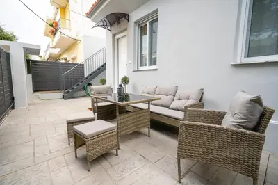 a patio with a table and chairs and a couch at Odysseas Palace in Athens in Athens