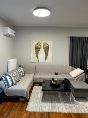 a living room with a couch and a table at comfort in Athens