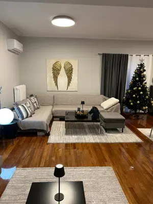 a living room with a couch and a christmas tree at comfort in Athens