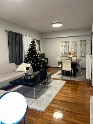 a living room with a christmas tree in the middle at comfort in Athens
