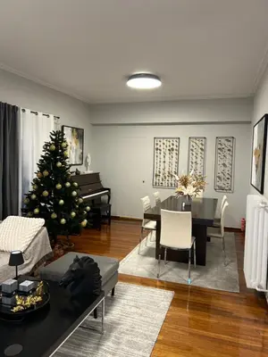 a living room with a christmas tree and a piano at comfort in Athens