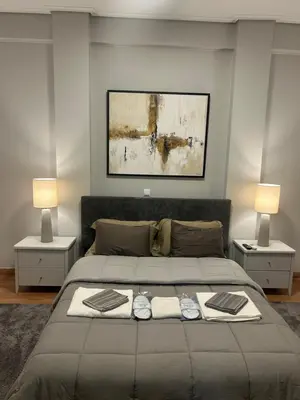 a bedroom with a large bed with two lamps at comfort in Athens