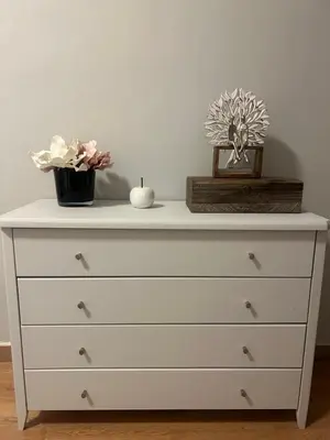 a white dresser with a candle and flowers on it at comfort in Athens