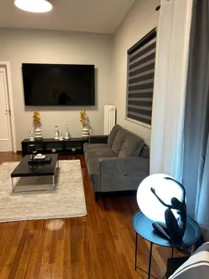 a living room with a couch and a table at comfort in Athens