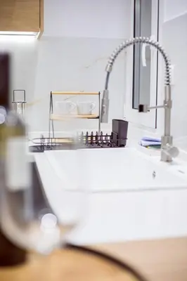 a kitchen counter with a sink and a faucet at CHIC and MODERN THISSIOs APARTMENT in Athens