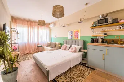 a living room with a bed and a kitchen at Hellinikos Suite - few steps from Acropolis in Athens