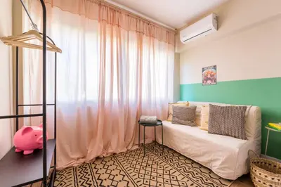 a bedroom with a bed and a pink curtain at Hellinikos Suite - few steps from Acropolis in Athens