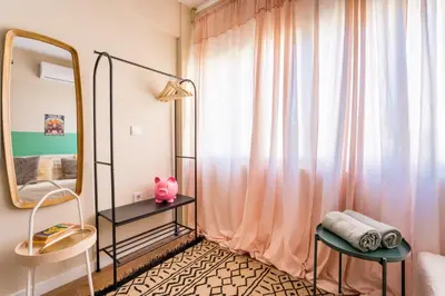 a bedroom with a mirror and a pink curtain at Hellinikos Suite - few steps from Acropolis in Athens