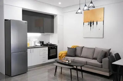 a living room with a couch and a kitchen at Cozy Home With Cooking in Piraeus