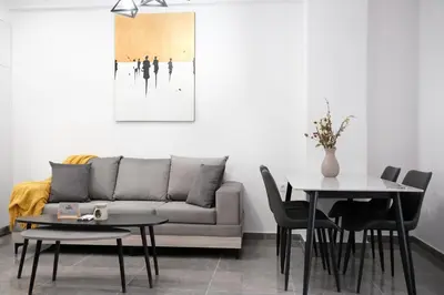 a living room with a couch and tables at Cozy Home With Cooking in Piraeus