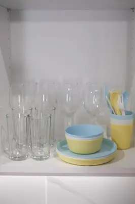 a shelf with glasses and a bowl and plates on it at Cozy Home With Cooking in Piraeus